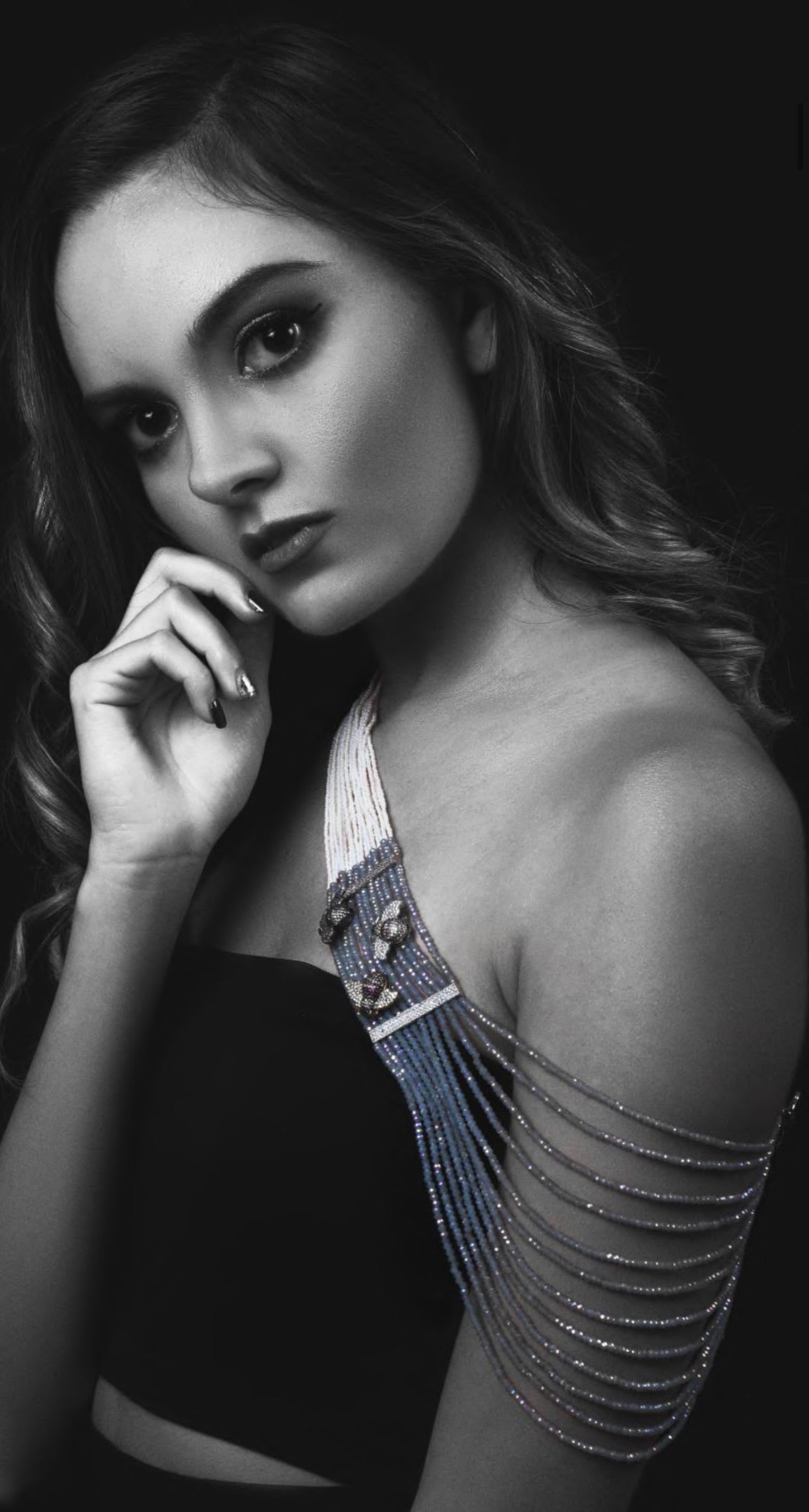 Black and white portrait of a woman with intricate shoulder design.